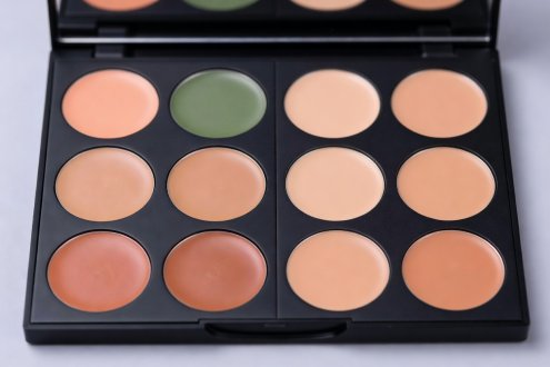 Close-up of color corrector palette containing peach, green, bisque, and rich terracotta shades